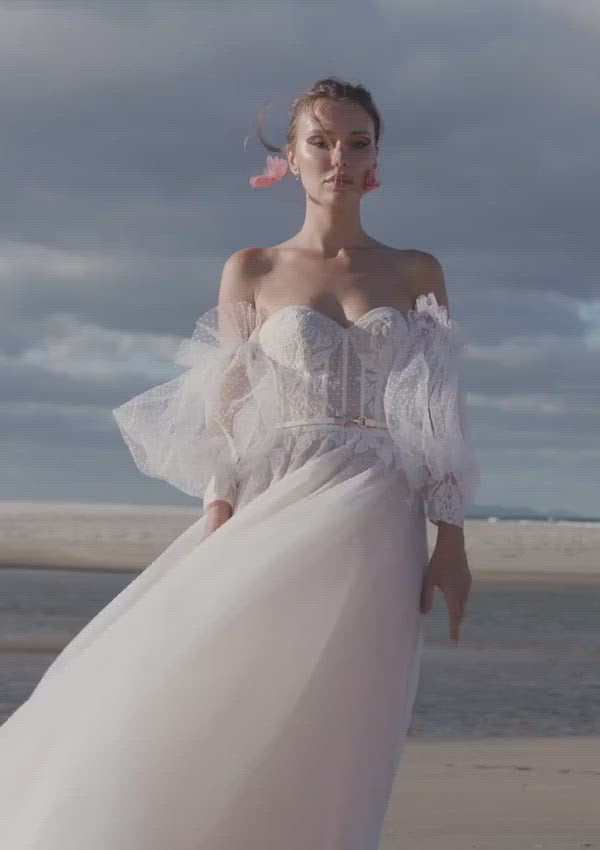 Sweetheart neckline wedding dress with hailstorm tulle that delicately floats around her A-line silhouette.