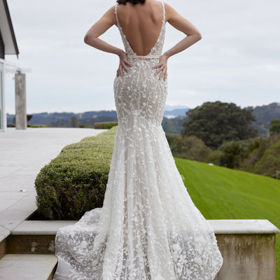 Back view of Noor gown with champagne lining and 3D floral ivory lace overlay. Plunging backline on a Mermaid silhouette and champagne satin waistband. 