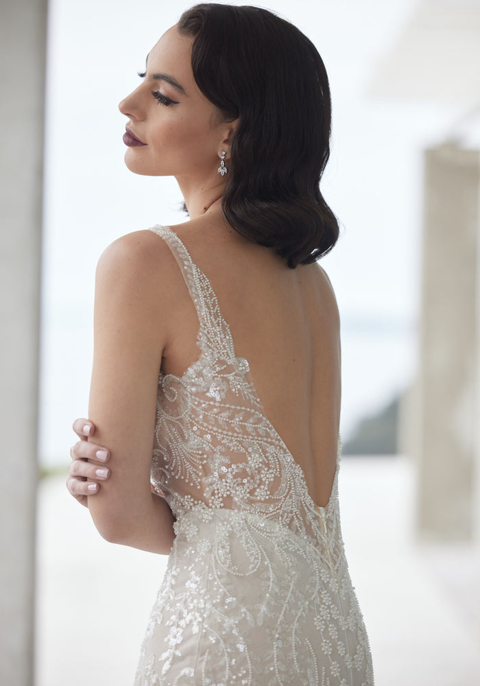 Back of tala gown showing leafy and floral beaded details on plunging backline.