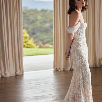 Heavily beaded trumpet silhouette gown with champagne lining. Side with with beaded train and off-the-shoulder soft tulle straps.