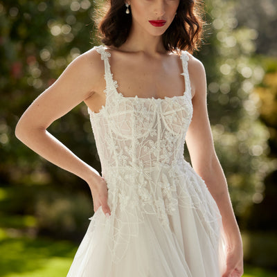 A-line square beaded neckline with visible boning through bodice.  Tulle fabric skirt with split over right leg.
