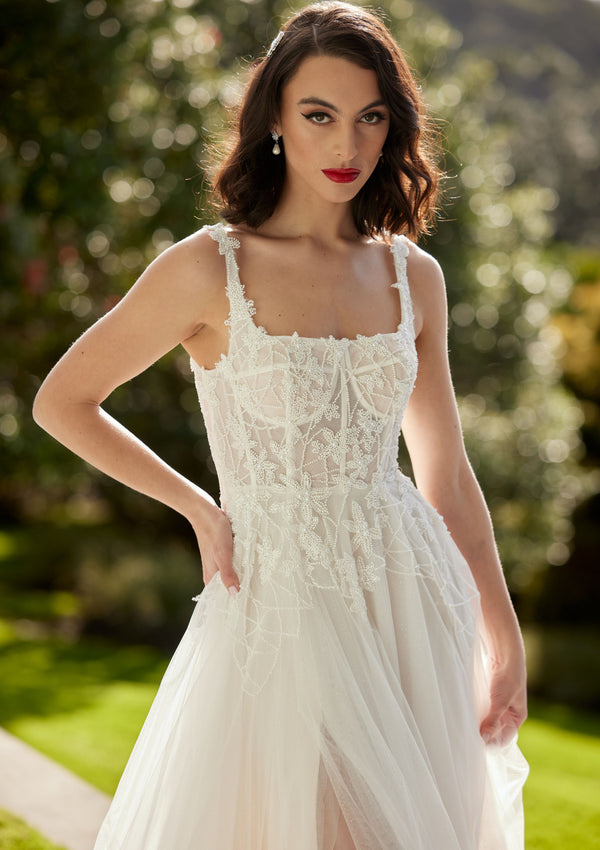 A-line square beaded neckline with visible boning through bodice.  Tulle fabric skirt with split over right leg.
