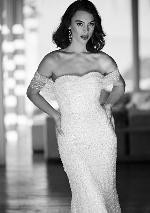 Black and white image of sequined and beaded Tavi gown. Ruched bodice with off the shoulder straps and figure-hugging silhouette