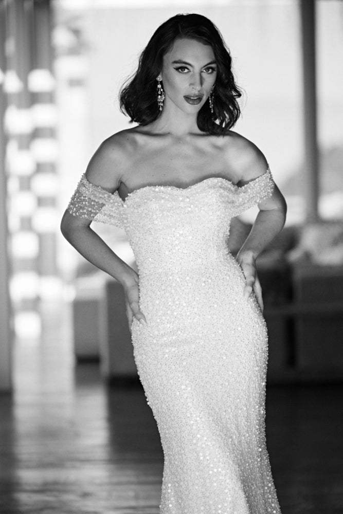 Black and white image of sequined and beaded Tavi gown. Ruched bodice with off the shoulder straps and figure-hugging silhouette
