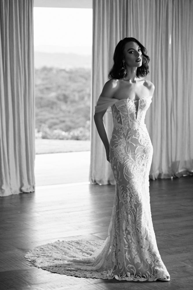 Black and white image of Tay gown. Heavily beaded trumpet silhouette gown with visible corsetry and soft tulle off the shoulder straps.