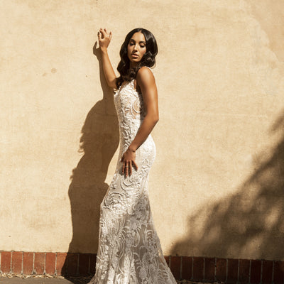Side view of Nikola gown in fully-beaded lace on a fit-n-flare silhouette. Beaded train.
