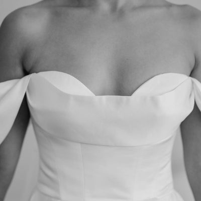Off-the-shoulder white satin high slit wedding dress.