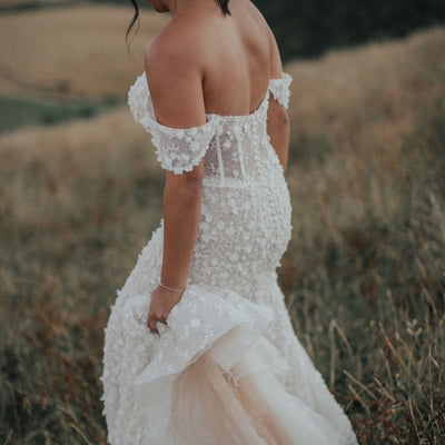 Off-the-shoulder sweetheart fit-and-flare wedding dress with floral lace detail.